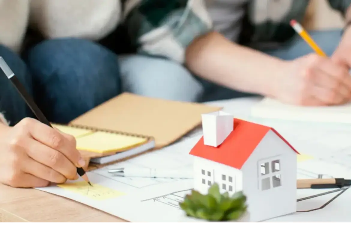 Familia planificando finanzas sobre planos de vivienda.